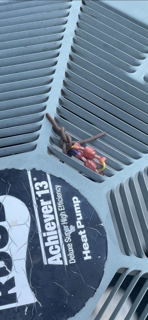 Close-up of an outdoor AC unit's top grille and wiring during an inspection by Air Fix in Fayetteville, AR.