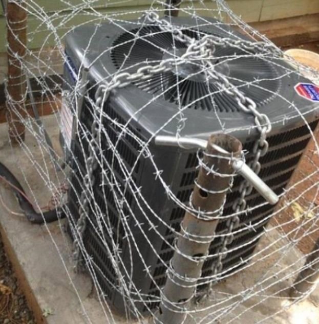 An outdoor air conditioning unit secured with barbed wire, serviced by All Metro Air Conditioning in Apache Junction, AZ.