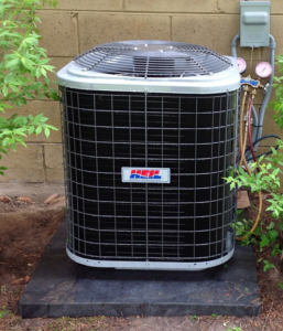 An outdoor air conditioning unit with service gauges connected by an HVAC Logistics technician in Albuquerque, NM
