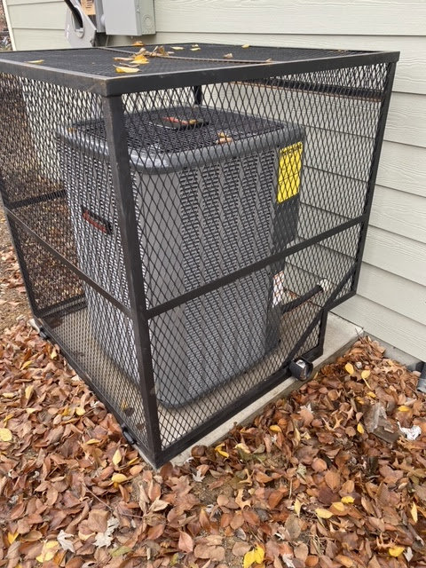An outdoor air conditioning unit protected by a metal cage, serviced by Chill Out Heating and Cooling in Tulsa, OK.