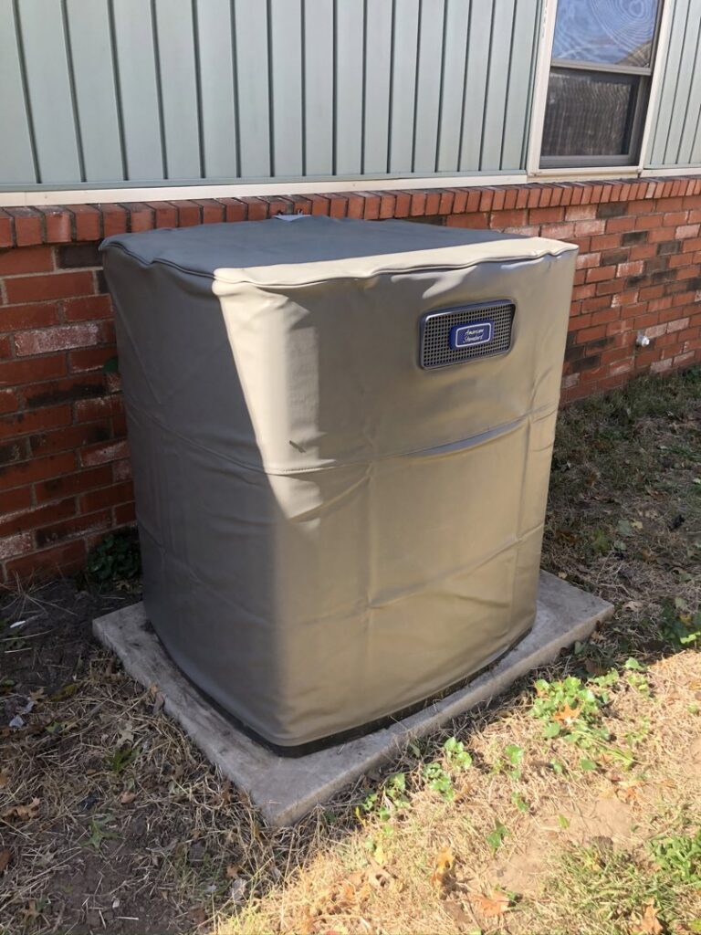An outdoor air conditioning unit with a protective cover installed by Crouch's Heating & Cooling LLC in Stillwater, OK.