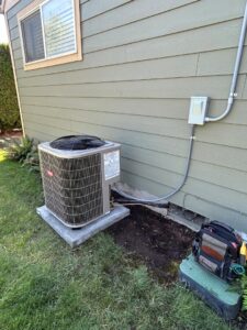 An outdoor Bryant air conditioning unit with a technician's tool bag nearby by Gagles Heating in Salem, OR.