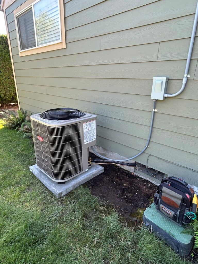 An outdoor Bryant air conditioning unit with a technician's tool bag nearby by Gagles Heating in Salem, OR.