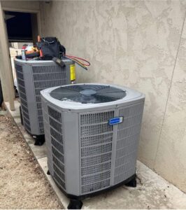 Two outdoor AC units with HVAC tools and hoses nearby, indicating service by OKIE Heating and Cooling in Tulsa, OK.