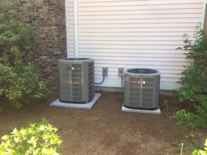 Two outdoor air conditioner units installed next to a residential building by R&M Mechanical Services LLC in Londonderry, NH