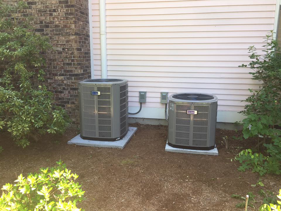 Two outdoor air conditioner units installed next to a residential building by R&M Mechanical Services LLC in Londonderry, NH