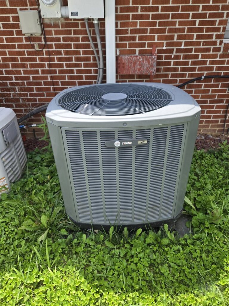An outdoor air conditioning unit installed next to a brick building by Childers Air Plumbing & Electric in Beckley, WV.