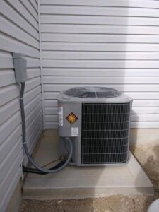 An outdoor air conditioning unit installed next to a residential building by Element Heating & Cooling, Inc. in Twin Falls, ID
