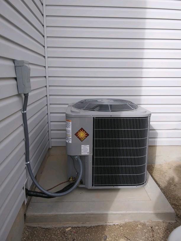 An outdoor air conditioning unit installed next to a residential building by Element Heating & Cooling, Inc. in Twin Falls, ID