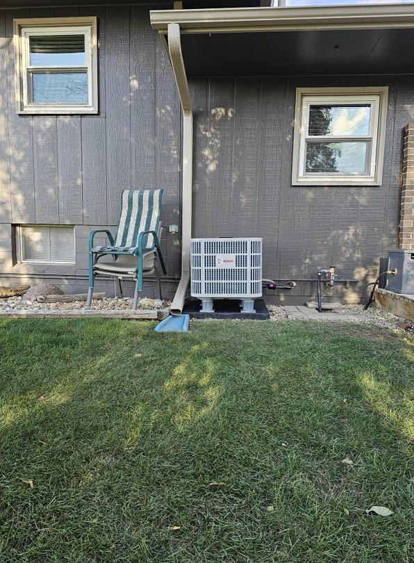 An outdoor air conditioning unit installed next to a home by Reliance Heating & Cooling in Yankton, SD.
