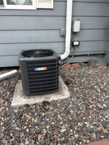 An outdoor air conditioning condenser unit installed on a concrete pad by Fine Line HVAC LLC for cooling services in Isanti, MN.