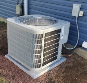 A newly installed outdoor air conditioning unit next to a blue house, completed by JK Mechanical in Willow Street, PA.