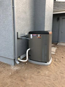 An outdoor air conditioning unit installed next to a residential building by Nevada Heating Reno in Sparks, NV.