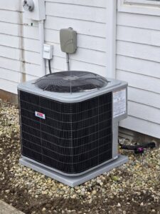 A newly installed outdoor air conditioning unit next to a residential building by Warren Mechanical, LLC in Carmel, IN.