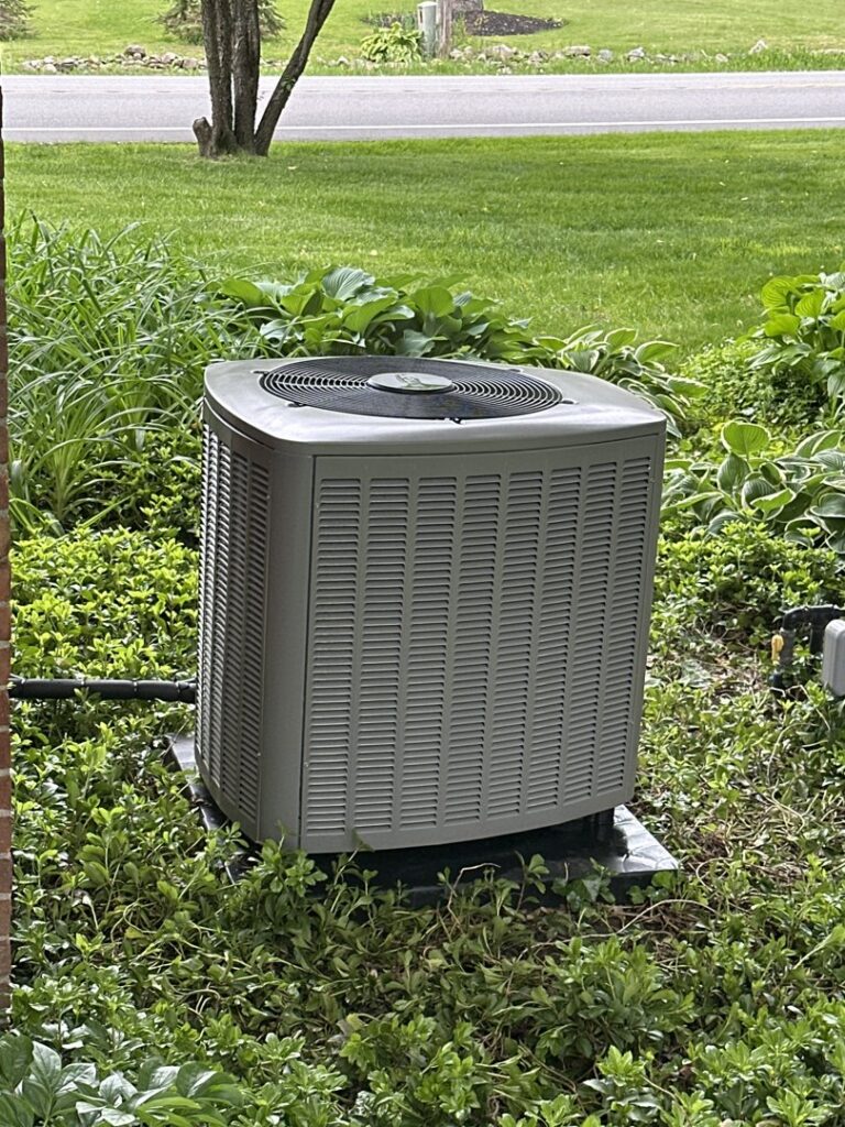 An outdoor air conditioning unit installed at a residential property by Isaac Heating & Air Conditioning in Rochester, NY.