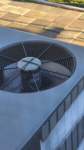 A close-up top view of an outdoor air conditioning unit serviced by Komfort Air Service Experts in Charlotte, NC.