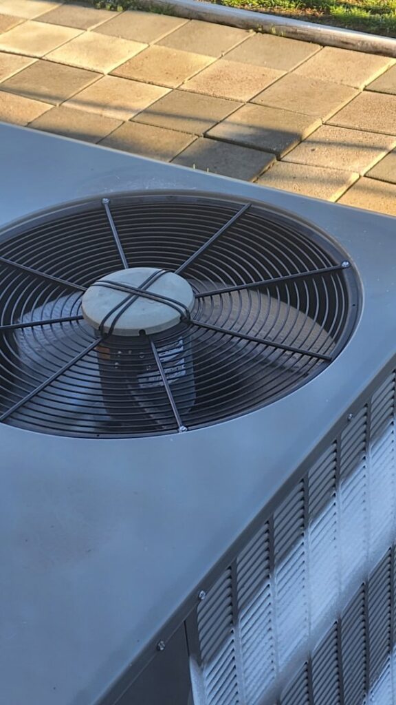A close-up top view of an outdoor air conditioning unit serviced by Komfort Air Service Experts in Charlotte, NC.