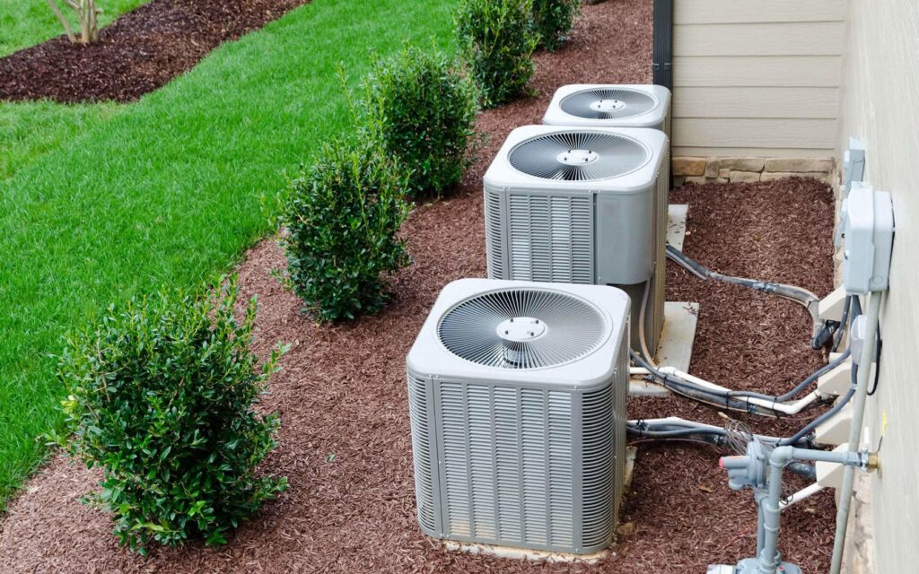 Multiple outdoor air conditioning units installed next to a home by Air Doctors Heating and Air Conditioning in Kenosha, WI.