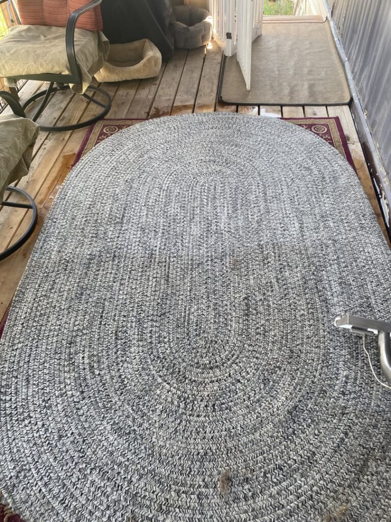 A large braided rug being professionally cleaned outdoors, showcasing rug cleaning services by B of C Carpet Cleaning LLC in Idaho Falls, ID.