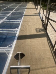 Outdoor carpet or turf being professionally cleaned, showing a clean section by TCK Carpet Cleaning in Indianapolis, IN.