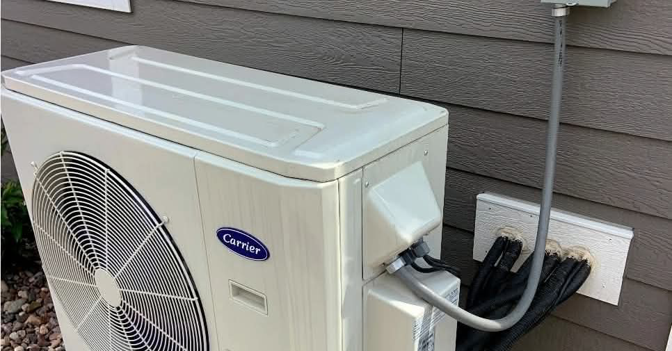 An outdoor Carrier heat pump unit professionally installed by Maine Heat Pumps, LLC in Saco, ME