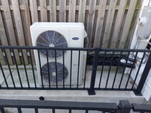 An outdoor Carrier brand heat pump or AC condenser unit, ready for installation or service by Simply Home Service in Gaithersburg, MD.