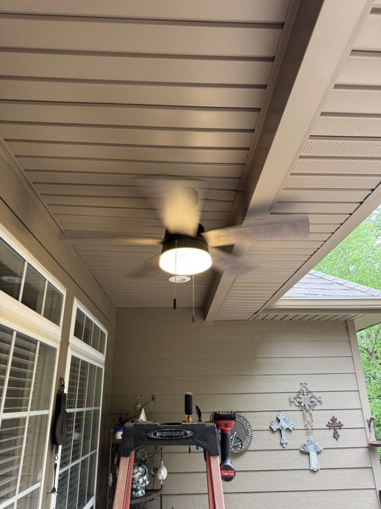 An outdoor ceiling fan with light, recently installed by McCurley Electric, with tools visible in Little Rock, AR.