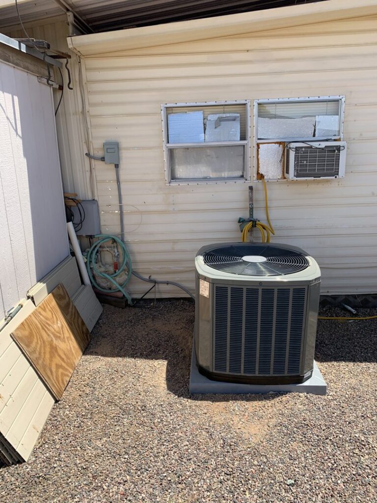 An outdoor condenser unit installed next to a mobile home, serviced by Valle Del Sol Home Services, LLC in Scottsdale, AZ.