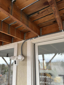 Outdoor conduit and light fixture installation under a deck by Regal Electrical Services in West Jordan, UT.