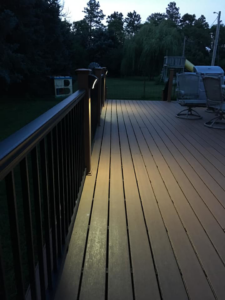 Outdoor deck lighting installation by McPhillips Electric LLC in Columbus, NE, showcasing illuminated railing posts at dusk.