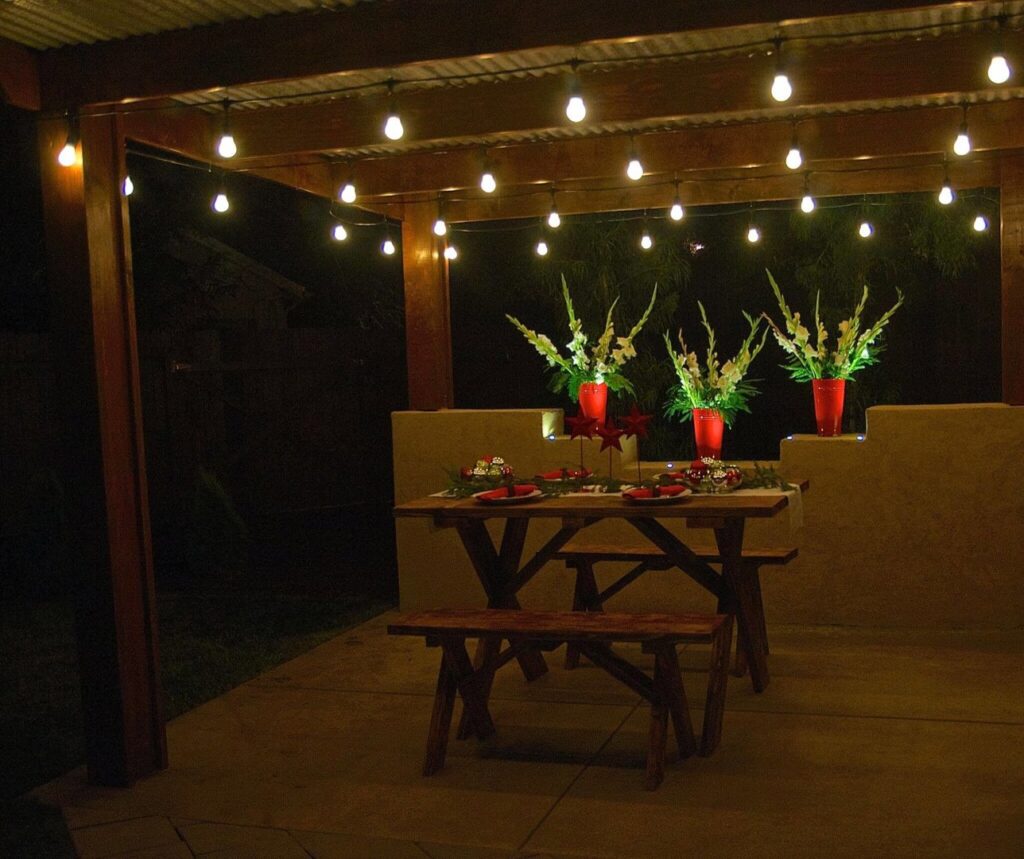 An outdoor dining area beautifully lit with string lights installed by The Lighting Geek in Sacramento, CA.