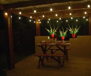 An outdoor dining area beautifully lit with string lights installed by The Lighting Geek in Sacramento, CA.
