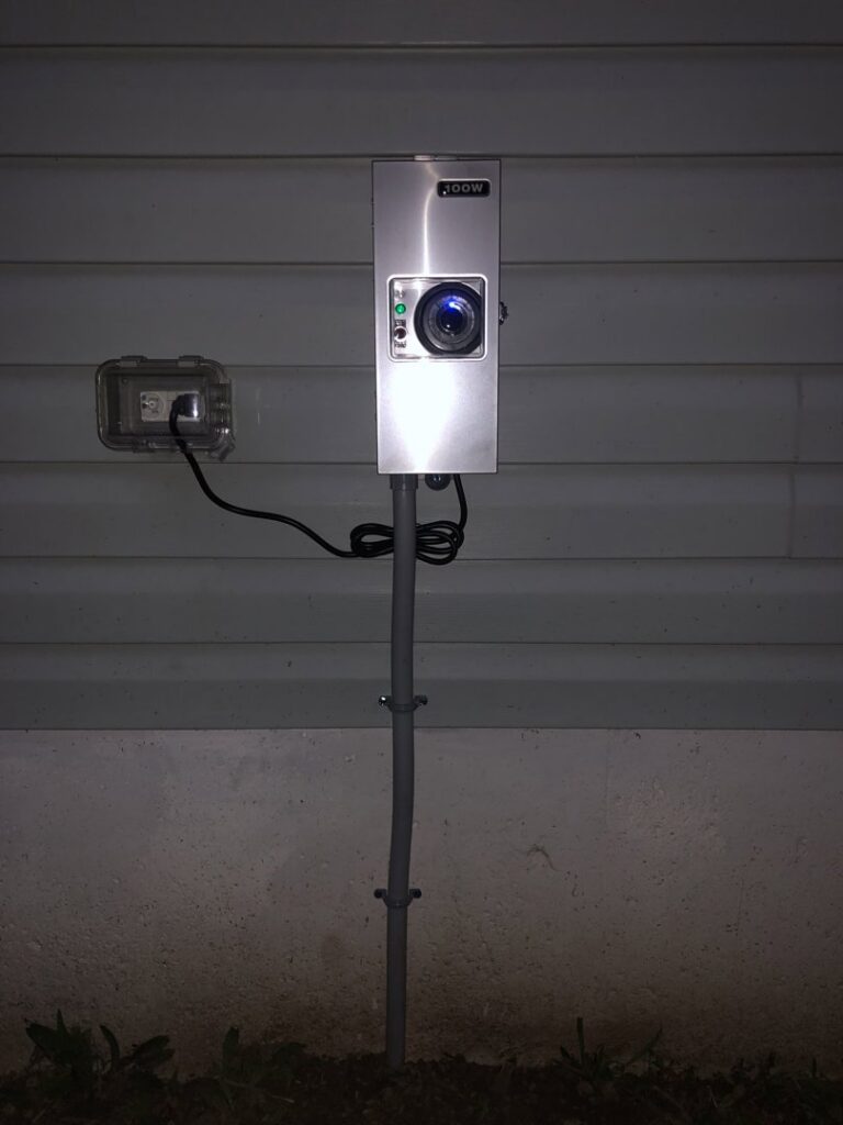 An outdoor electrical box with a camera or sensor and an adjacent outlet, installed by Surge Electric LLC in Youngstown, OH.