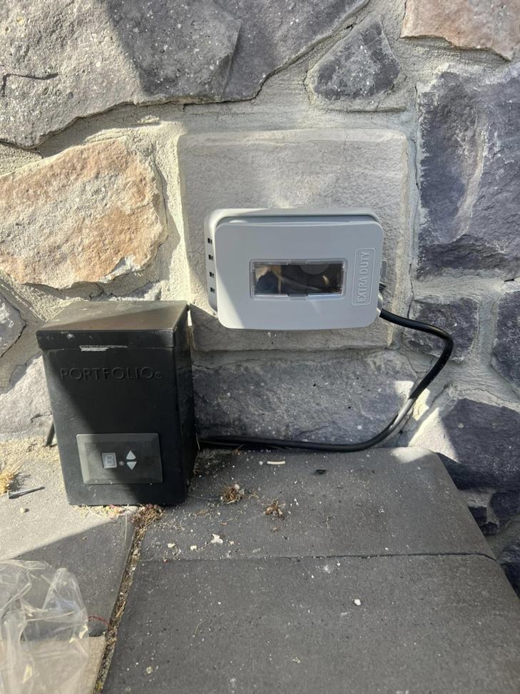 An outdoor 'EXTRA DUTY' electrical box and control unit installed on a stone wall by PnP Electric in Middletown, DE.