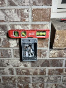 An outdoor electrical box being installed on a brick wall by Sparrow Electric, LLC in Denver, CO.
