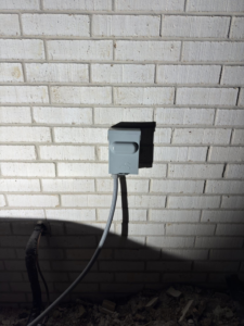 An outdoor electrical conduit box and wiring installed on a brick wall by Delta Current Electric in Jonesboro, AR.