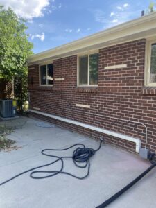 Outdoor electrical conduit and AC unit wiring installation on a brick house by All Electric llc in Denver, CO