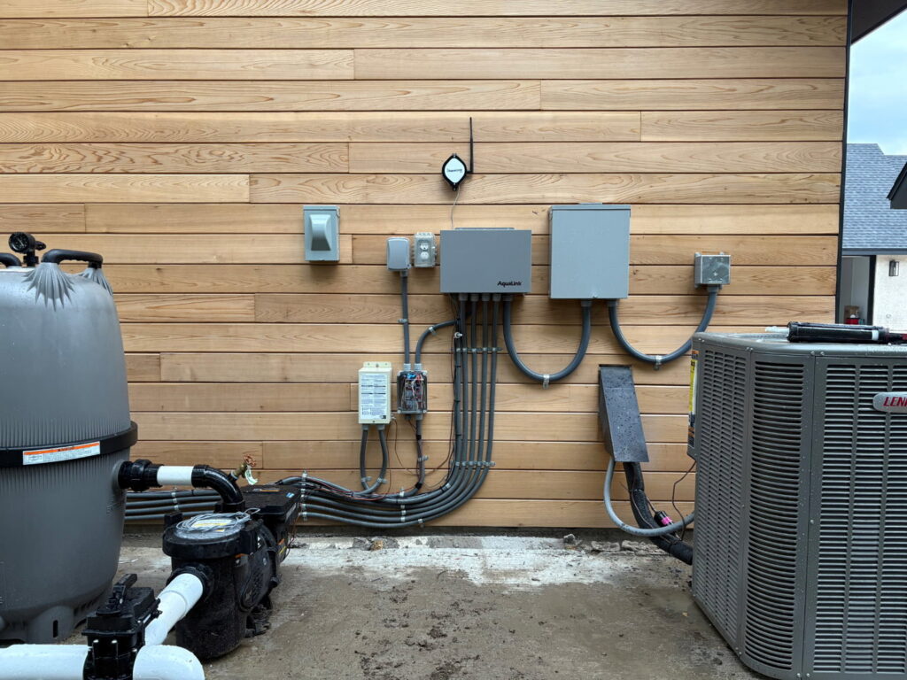 Complex outdoor electrical conduit and junction box installation next to a pool pump and HVAC unit by Mattox Electric, LLC in Dallas, TX.
