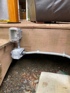 Outdoor electrical conduit and junction boxes installed on a deck by OutToday Electrical, Heating, Plumbing, and Air in Bellevue, WA