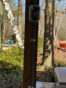 Outdoor electrical conduit and a weatherproof box installed on a wooden post by Pierce Electric, LLC in Fayetteville, NC