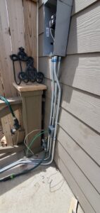 Outdoor electrical conduit and wiring installation on a house exterior by Midway Electric Inc. in Columbia, MO.