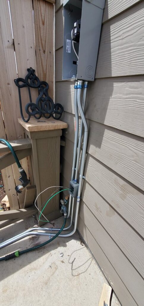 Outdoor electrical conduit and wiring installation on a house exterior by Midway Electric Inc. in Columbia, MO.