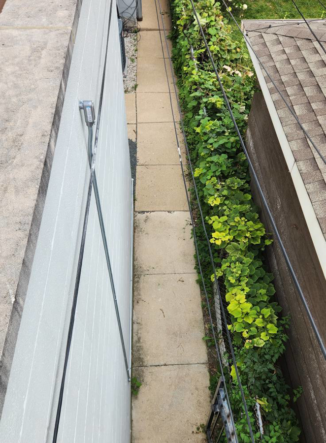 Outdoor electrical conduit and wiring installed along the side of a building by Ed's Electrical & Mounting services in Chicago, IL.