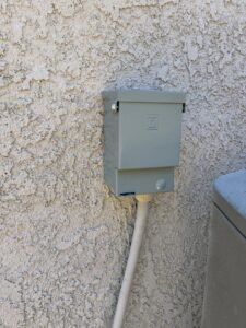 An outdoor electrical disconnect box installed on a stucco wall by HomeRun Electric LLC in Arlington, TX