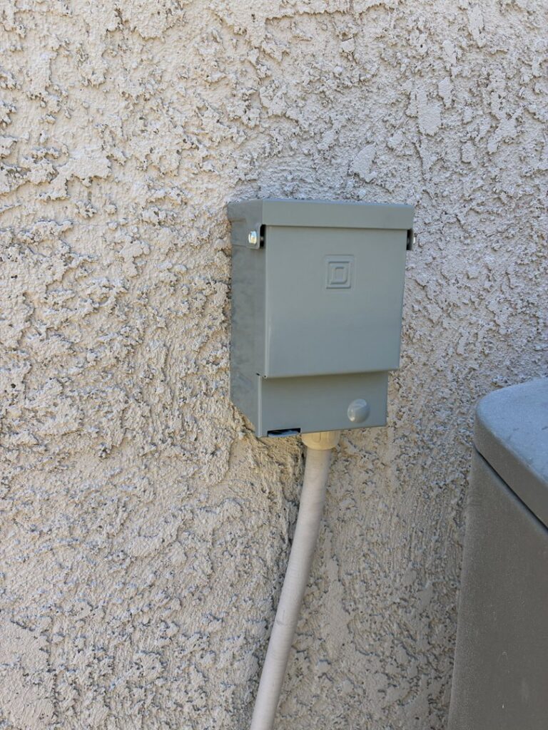 An outdoor electrical disconnect box installed on a stucco wall by HomeRun Electric LLC in Arlington, TX