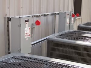 Outdoor electrical disconnects and control panels mounted next to HVAC units by Argosy Electric, Inc. in Newport News, VA