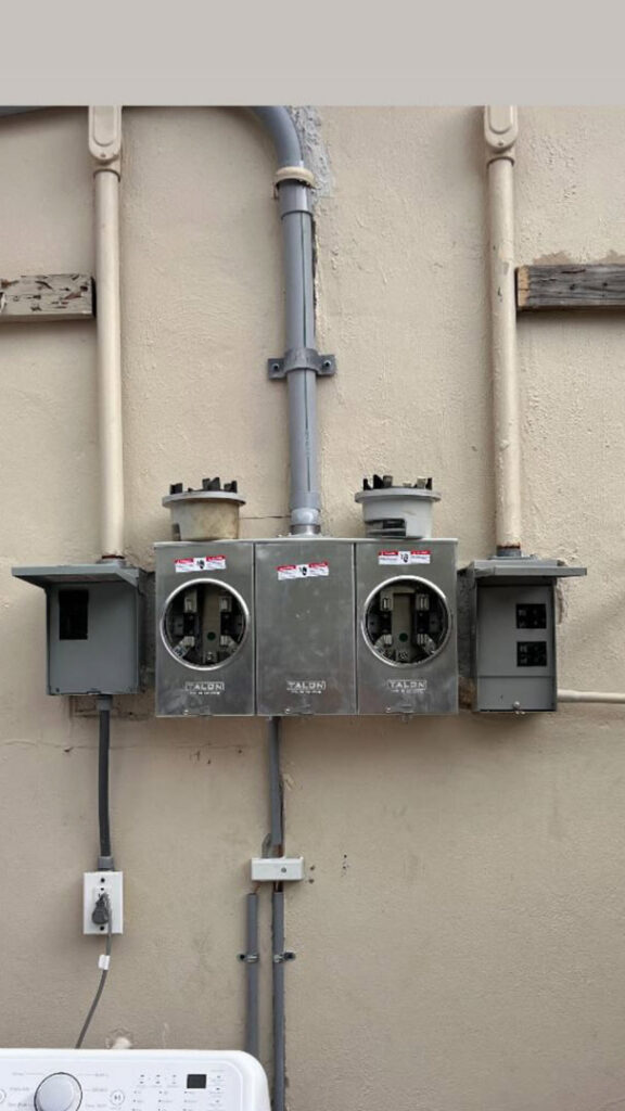 An outdoor electrical meter bank installation on a building exterior by Krakkom Electric in Sunrise, FL.