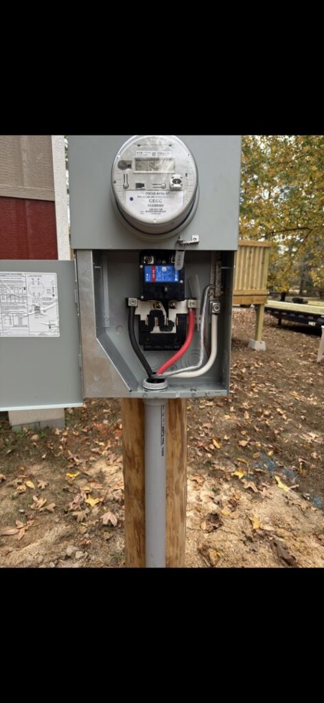 An outdoor electrical meter base with visible internal wiring, installed by Delta Current Electric in Jonesboro, AR.