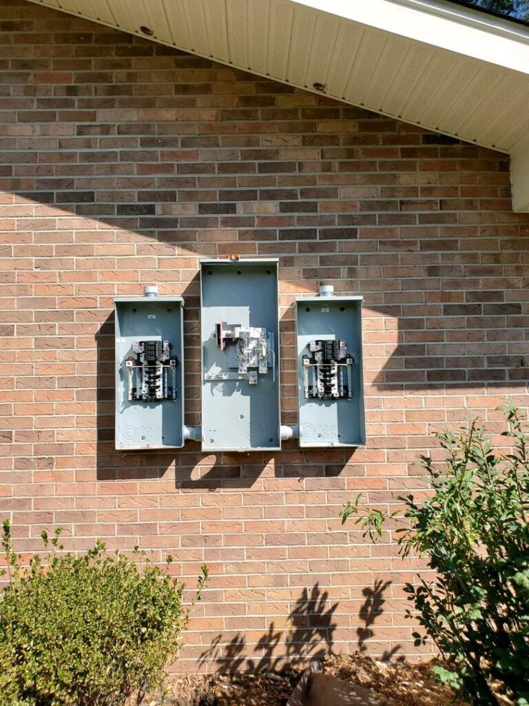 Three outdoor electrical meter bases installed on a brick wall by Discount Electrical Service of Franklin in Franklin, TN