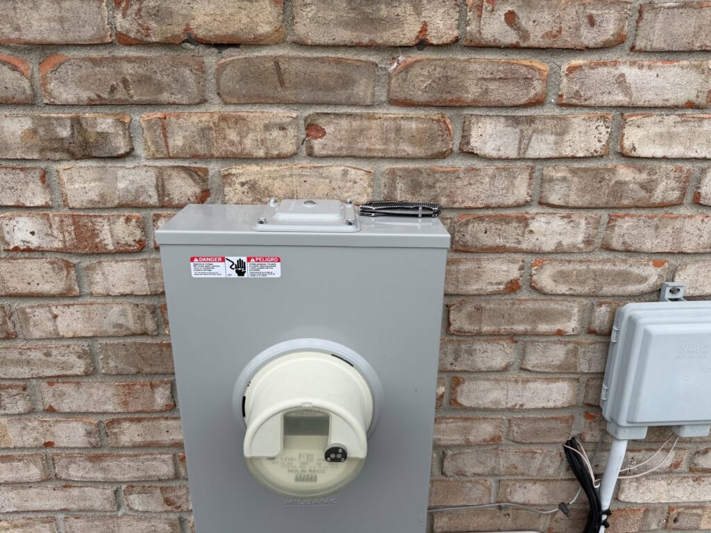 Outdoor electrical meter box installed on a brick wall by CM Electrical Solutions in Elizabethtown, KY.